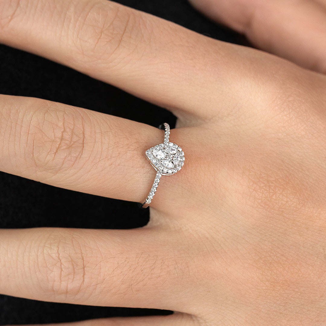 A woman's hand displaying a baguette cut diamond ring with smaller zircon stones set in a sterling silver band.
