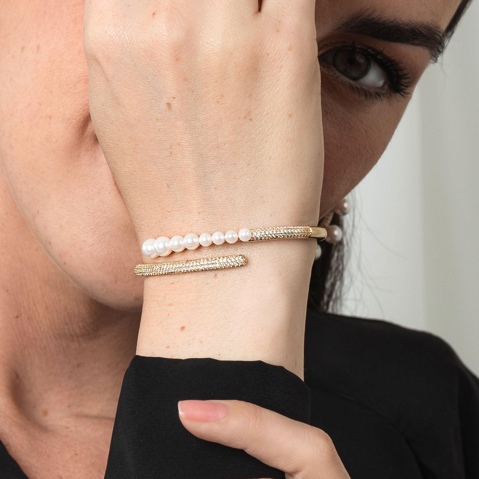 Pearl bracelet on a wrist with a neutral background