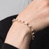 Pearl bracelet on a person's wrist against a neutral background