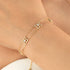 Gold bracelet with diamond accents on a wrist against a neutral background