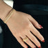 A gold-plated bangle set with a leafy halo design, worn on a person's wrist.