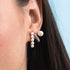 Close-up of an ear wearing pearl earrings with a blurred background