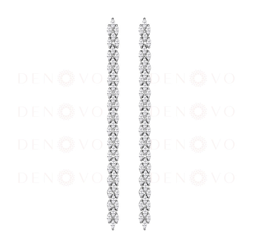 Pair of long, silver earrings with clear gemstones on a white background