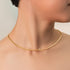 Gold necklace on a model against a neutral background