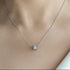 Silver necklace with a small pendant on a person's neck