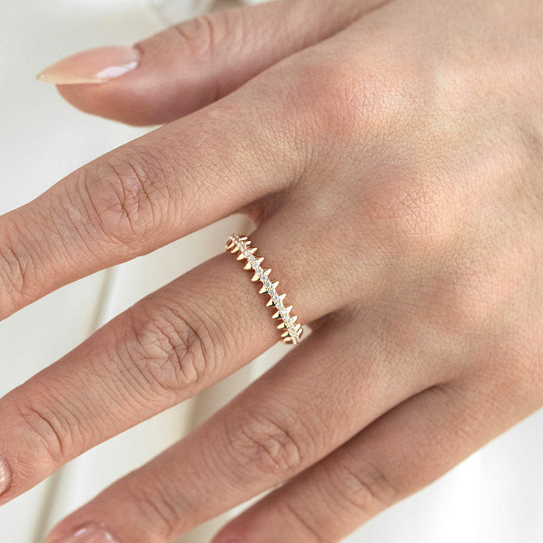 Gold ring on a person's finger against a white background
