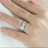 Silver ring on a person's finger against a white background