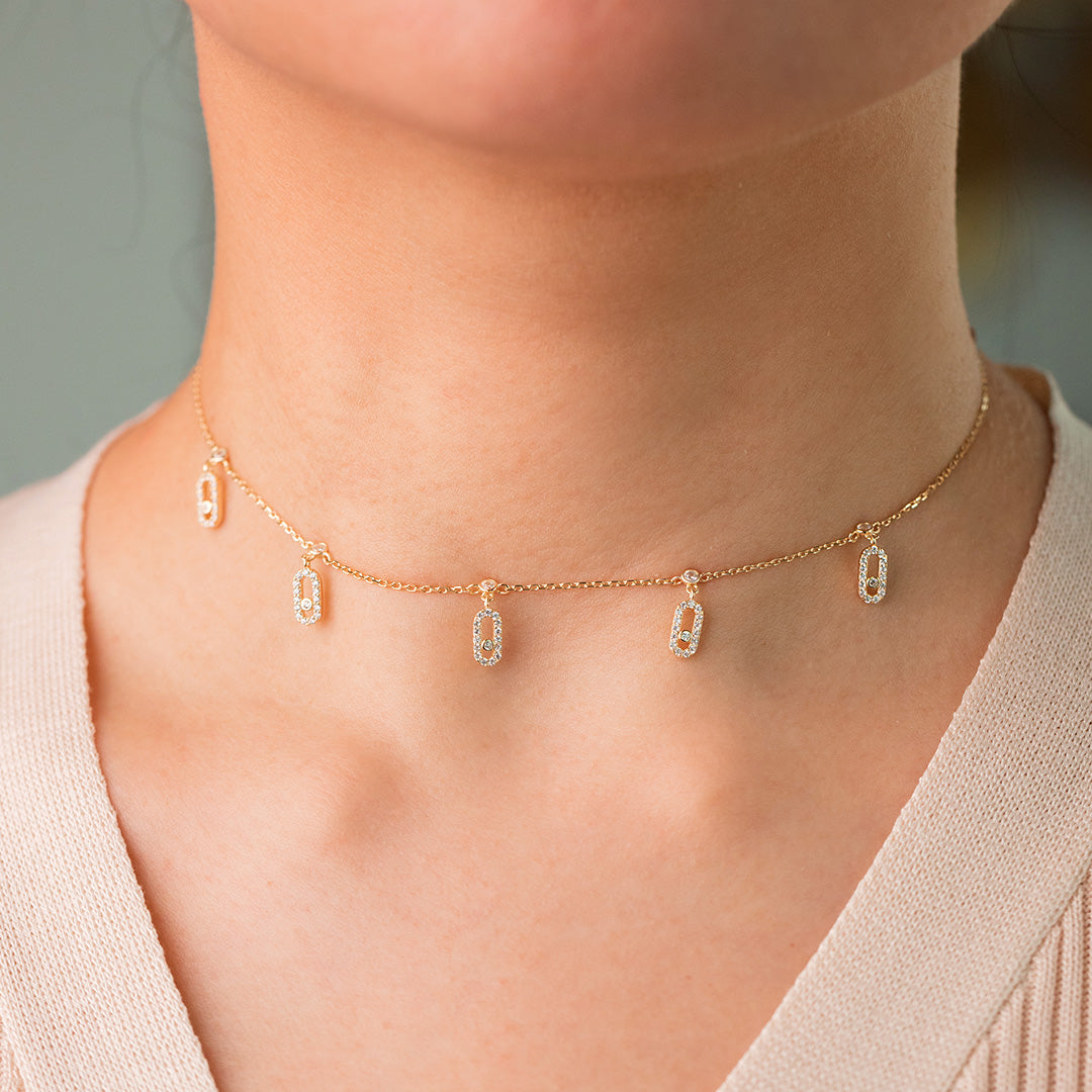 A woman wearing a sterling silver choker necklace with 18K gold plating and zircon stones.