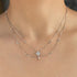 Close-up of a silver necklace with a star-shaped pendant on a person's neck.