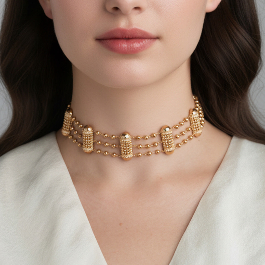 Gold necklace worn by a model against a neutral background