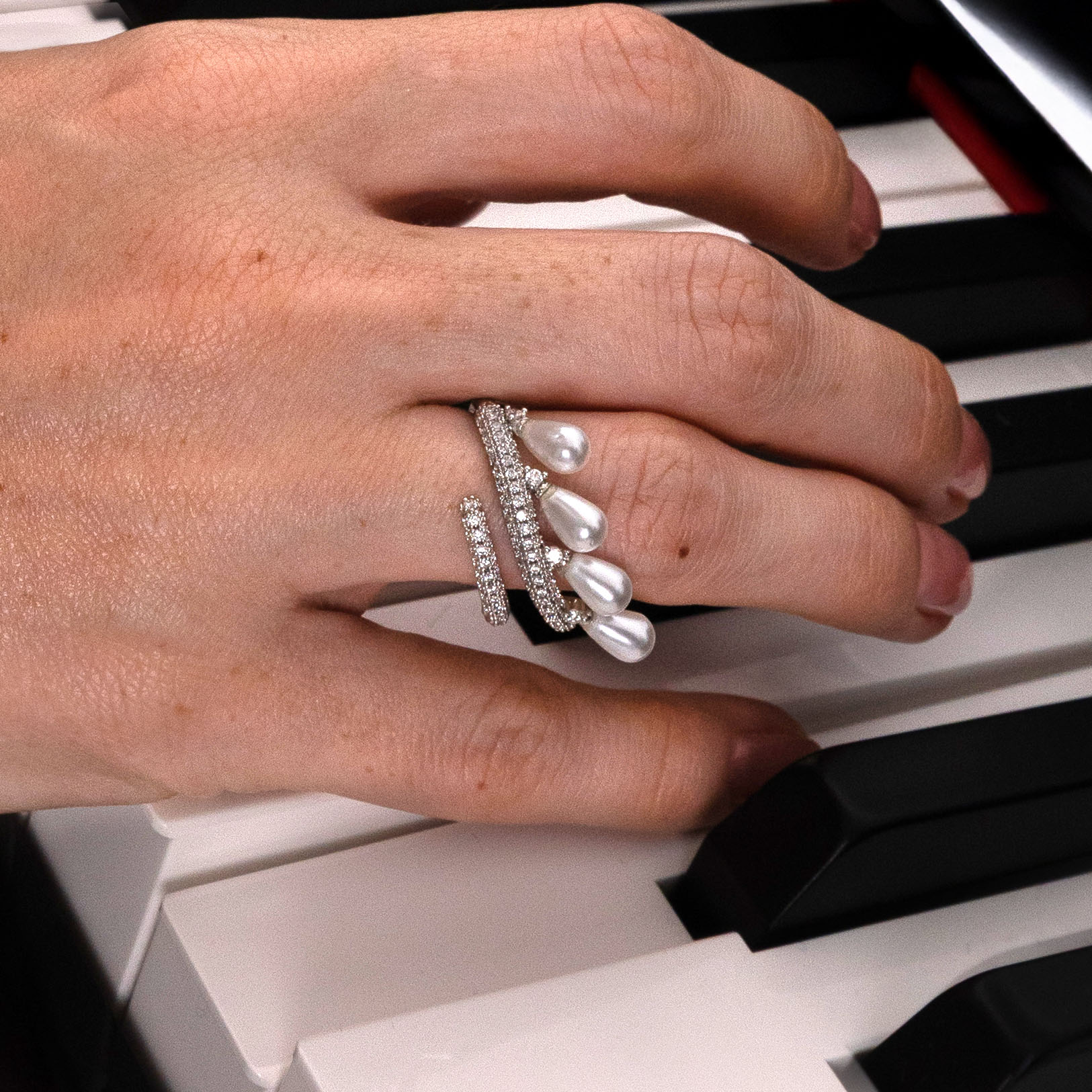 Hand with multiple rings on a piano keyboard