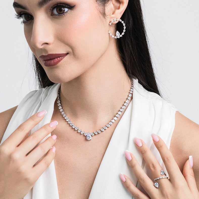 Woman wearing a diamond necklace and earrings on a white background