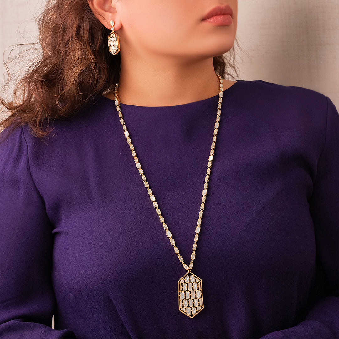 A woman wearing a purple dress and a gold-plated long chain set with zircon stones.